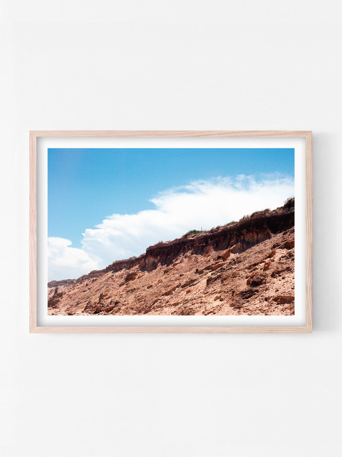 Thirteenth Beach Cliffs, Rocks and Clouds Landscape print in a natural oak shadowbox frame